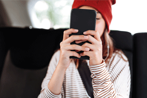 Girl in car with phone in front of face