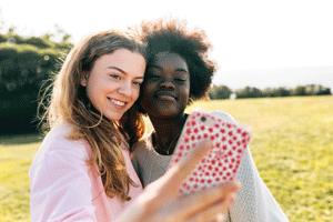 Two girls taking selfie in field