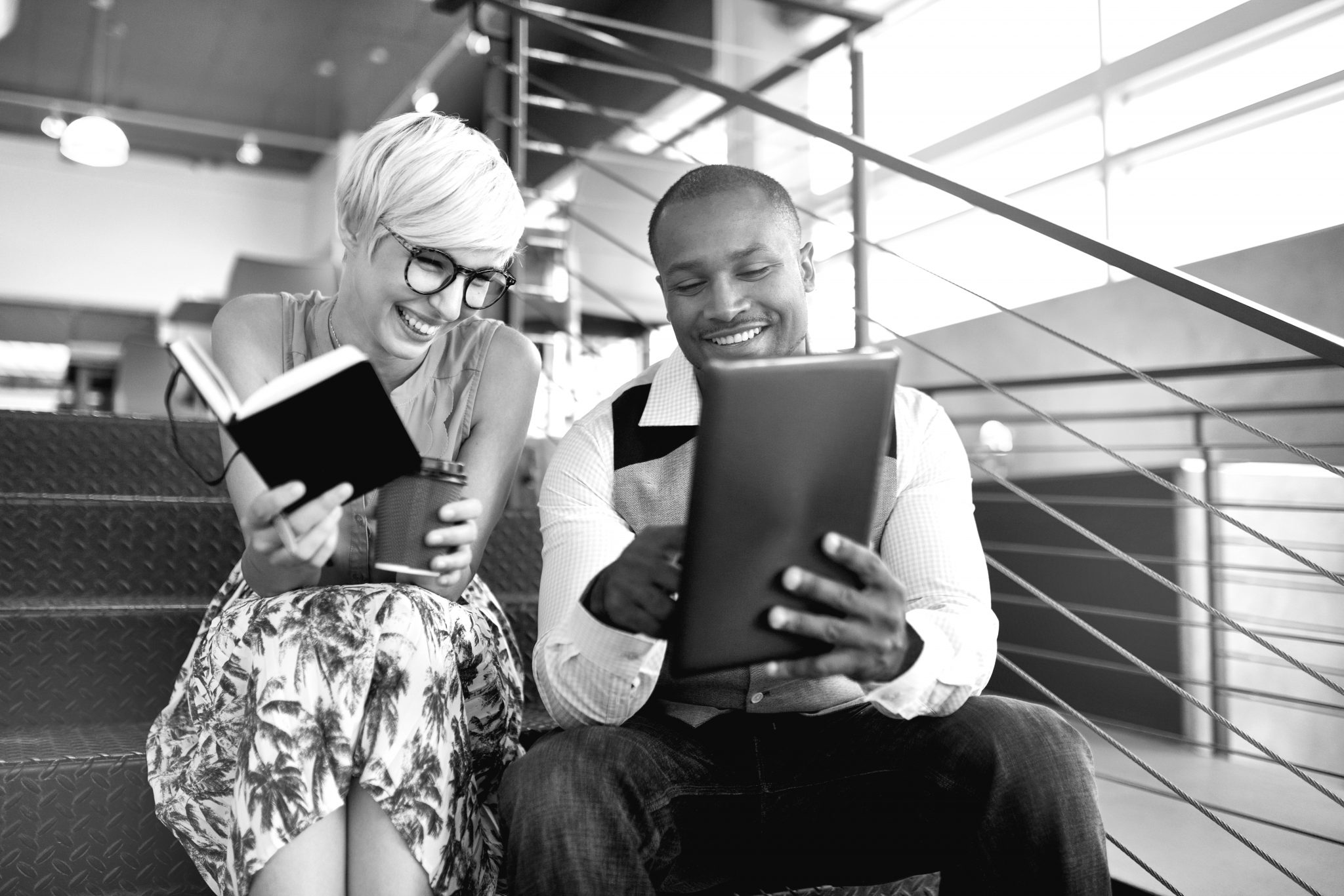 Photo of a young woman and a young man looking at a tablet