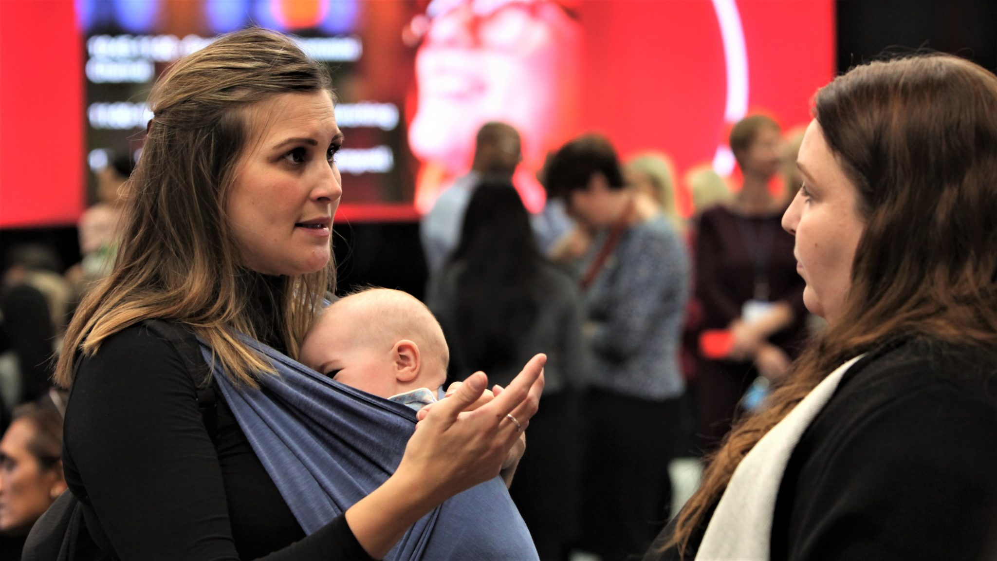 Woman with baby discusses returning to work with a Vodafone helper