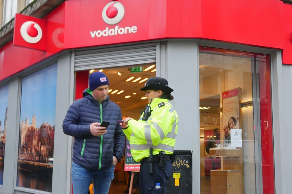 Police officer talking to member of the public outside Vodafone's Oxford Street store