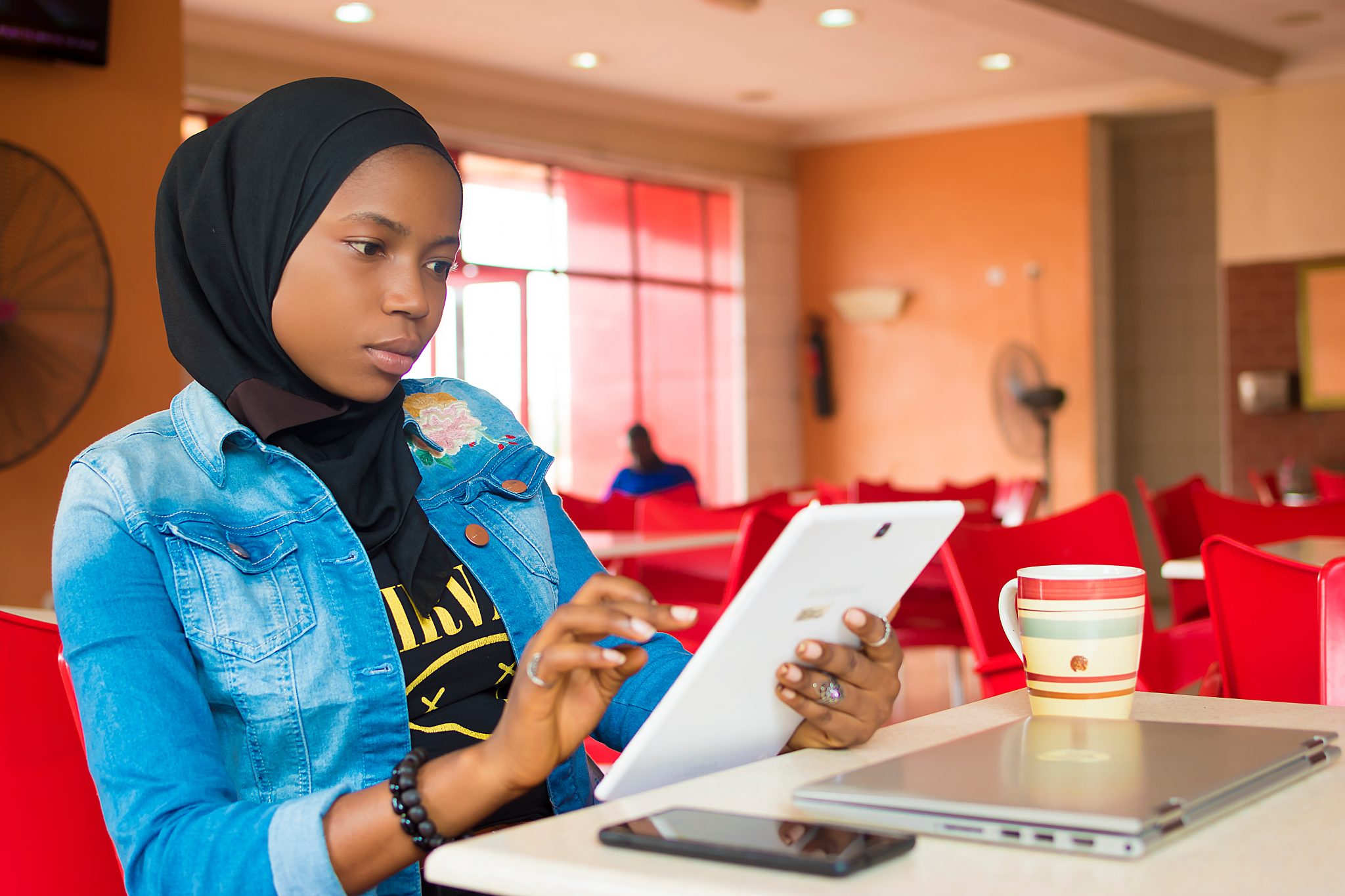 Nigerian muslim girl accessing tablet computer