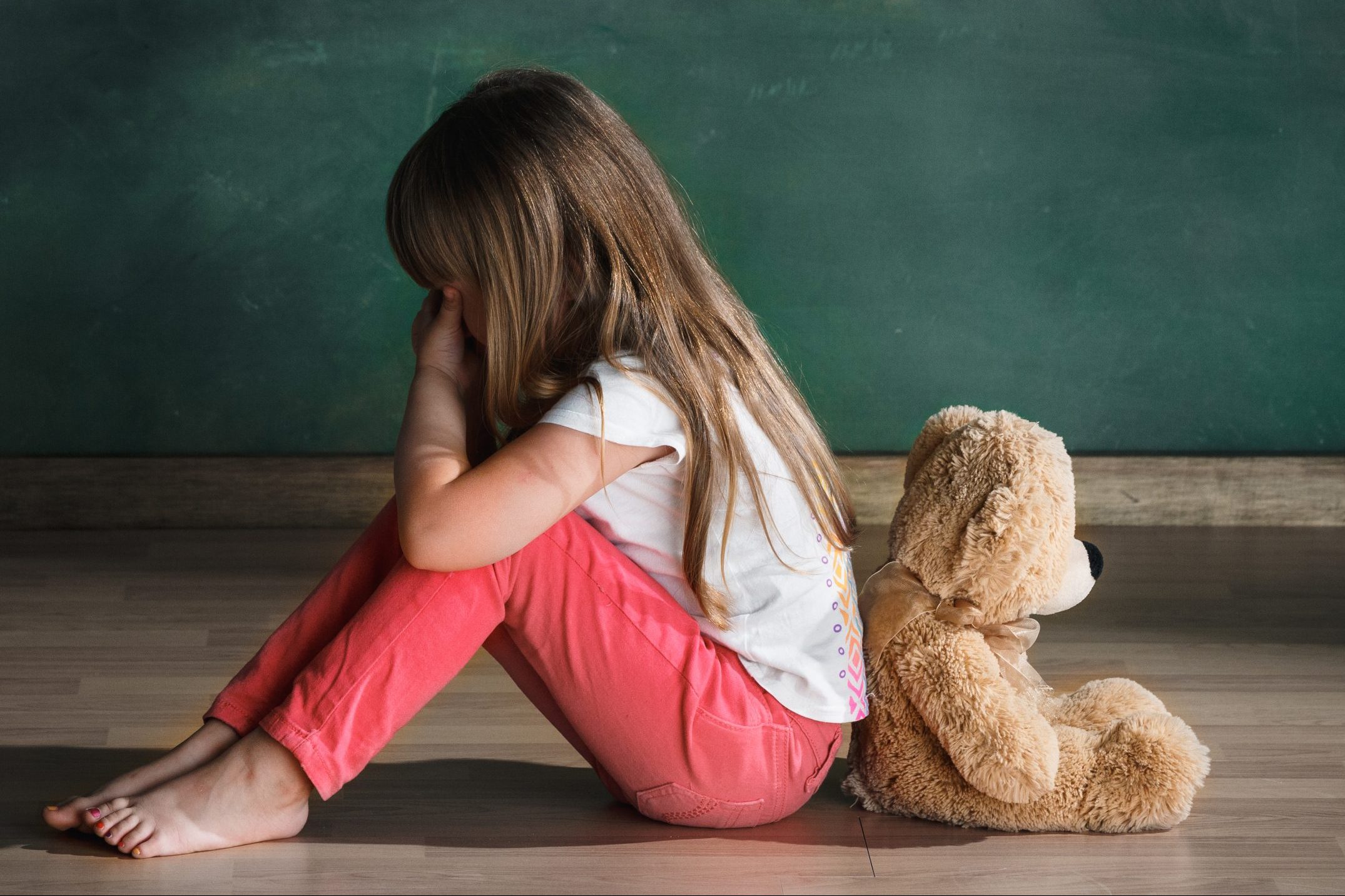 Young girl sitting with teddy bear