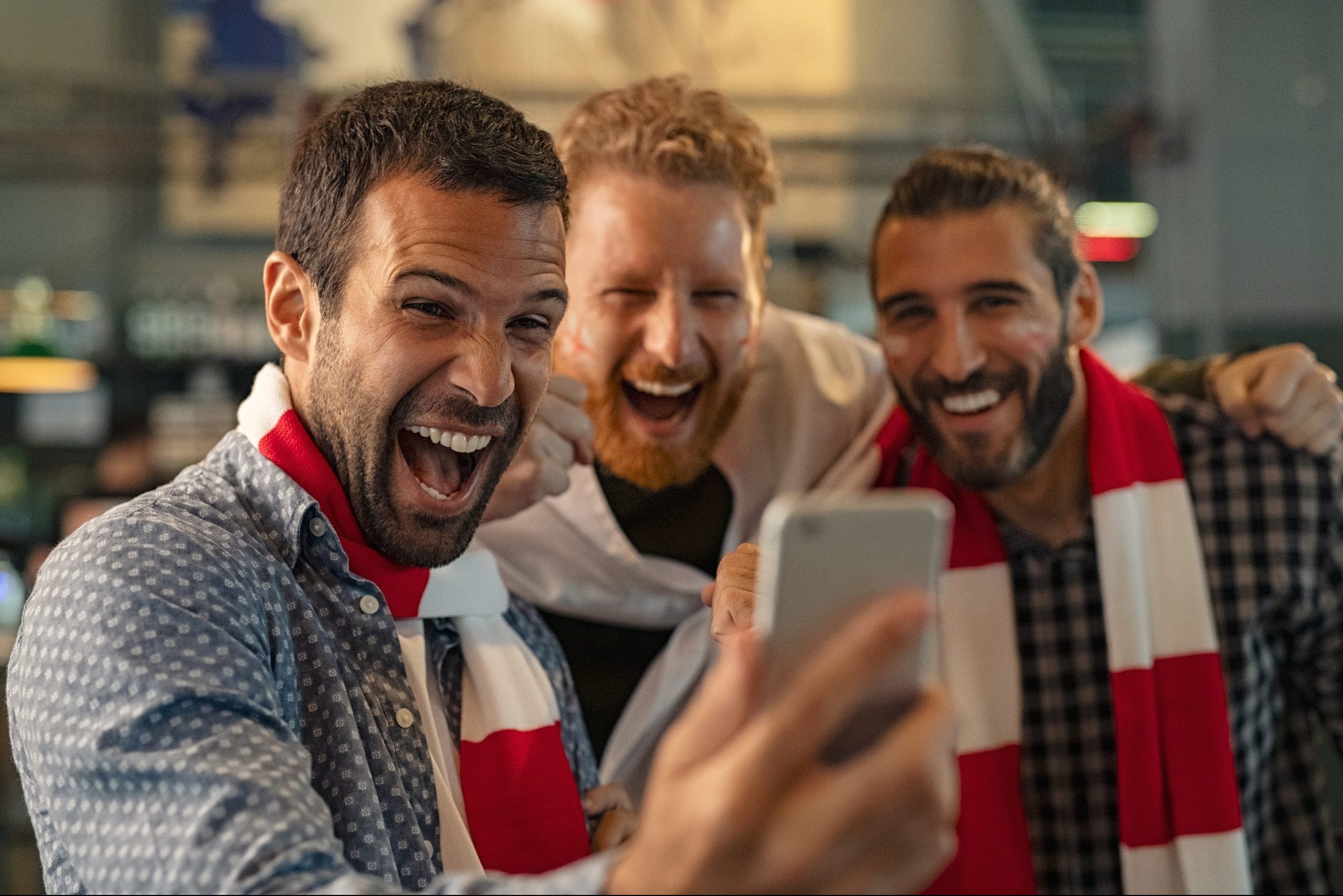 Football fans watching match on smartphone
