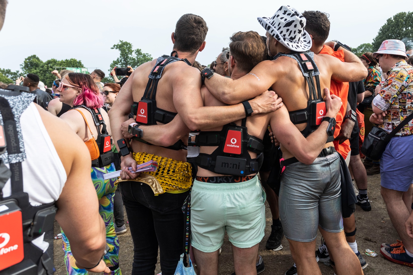 Rear view of male festival goers wearing Vodafone 5G haptic suits at Mighty Hoopla.