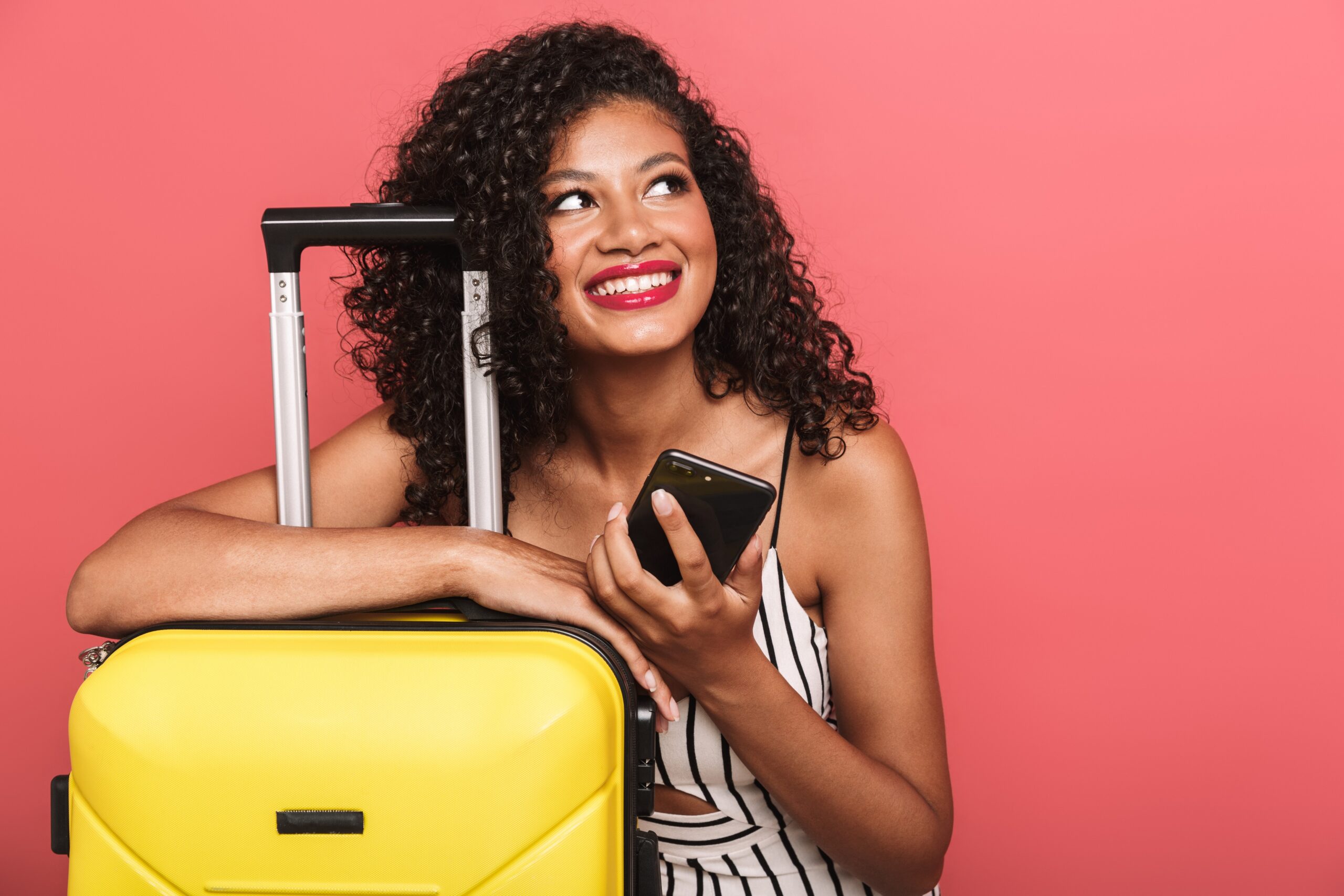 Young woman with suitcase and smartphone
