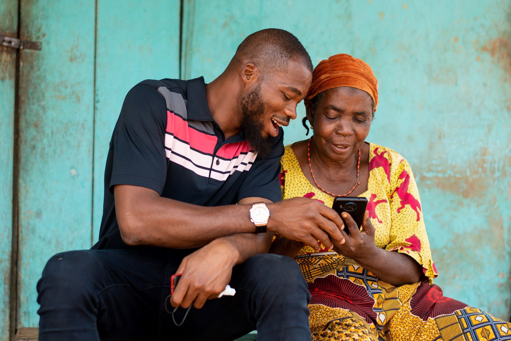 Young Man Helping Older Woman With Smartphone