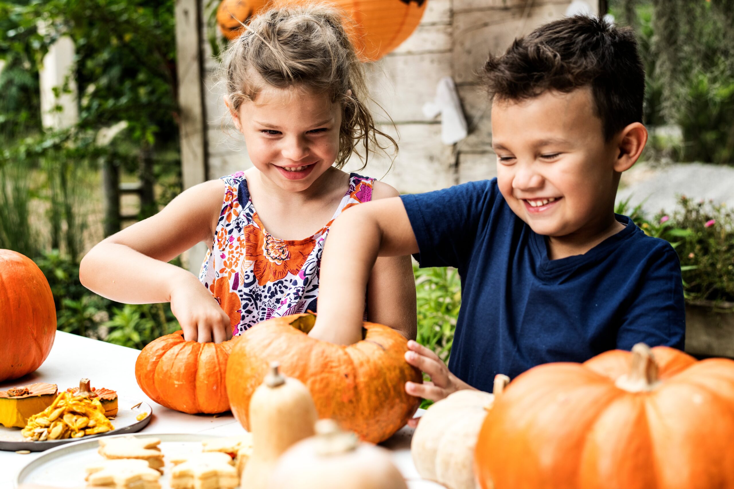 Girl and boy carve pumpkins