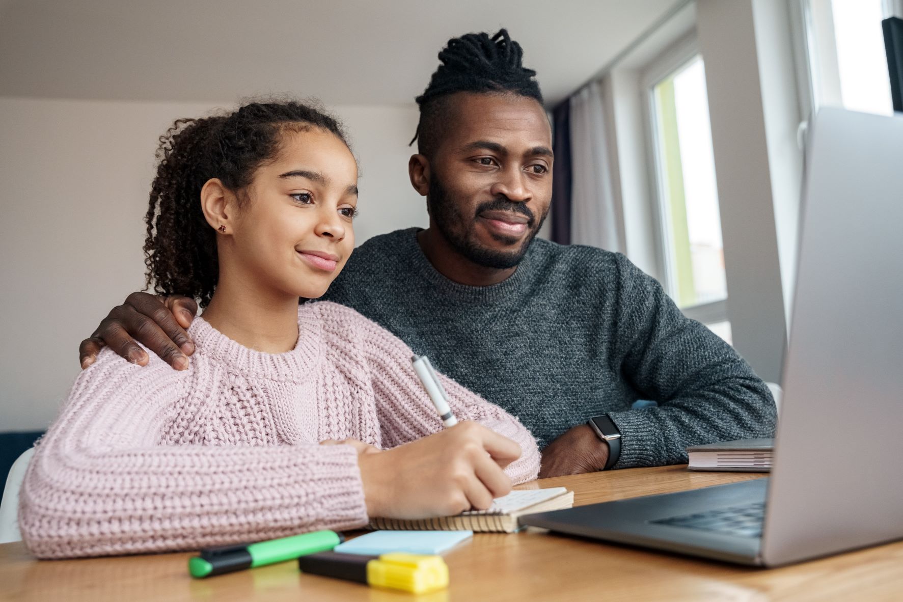 Father and daughter learning at laptop