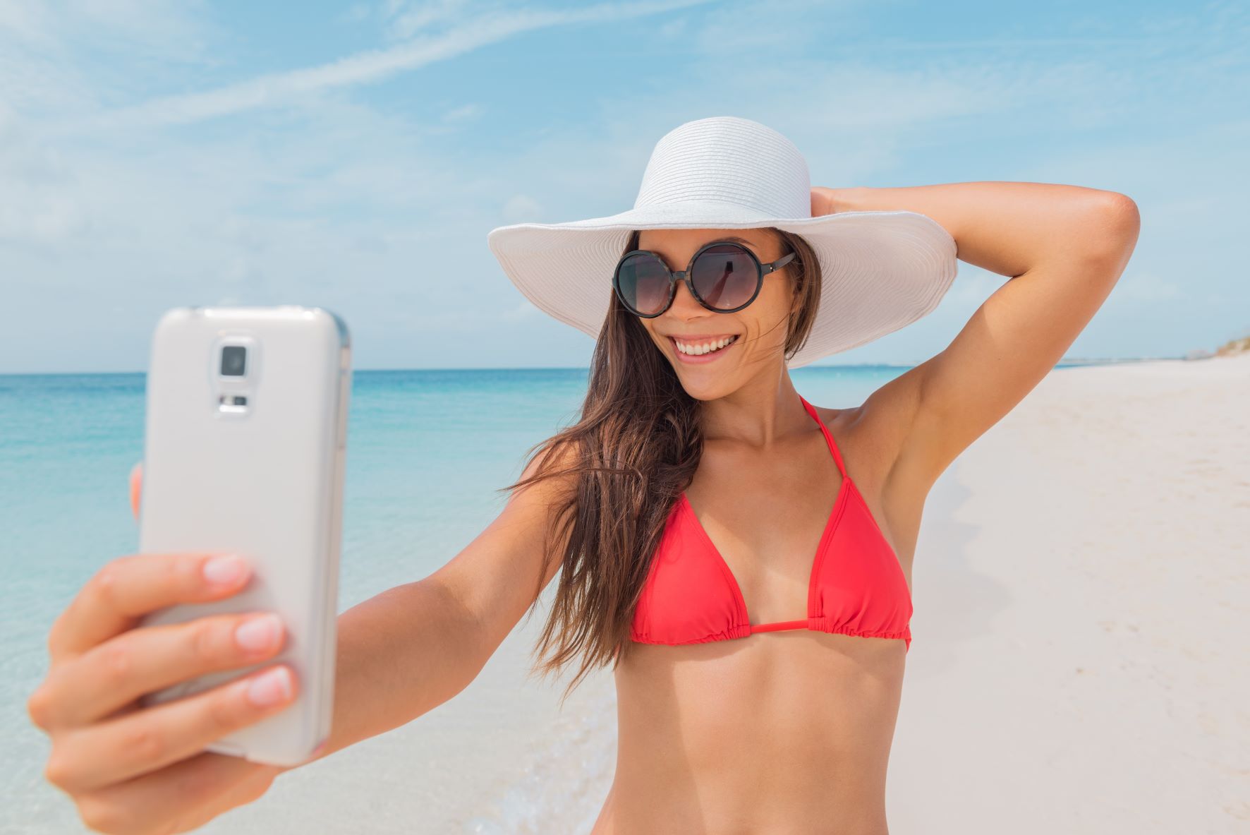 Young woman on a beach taking a selfie