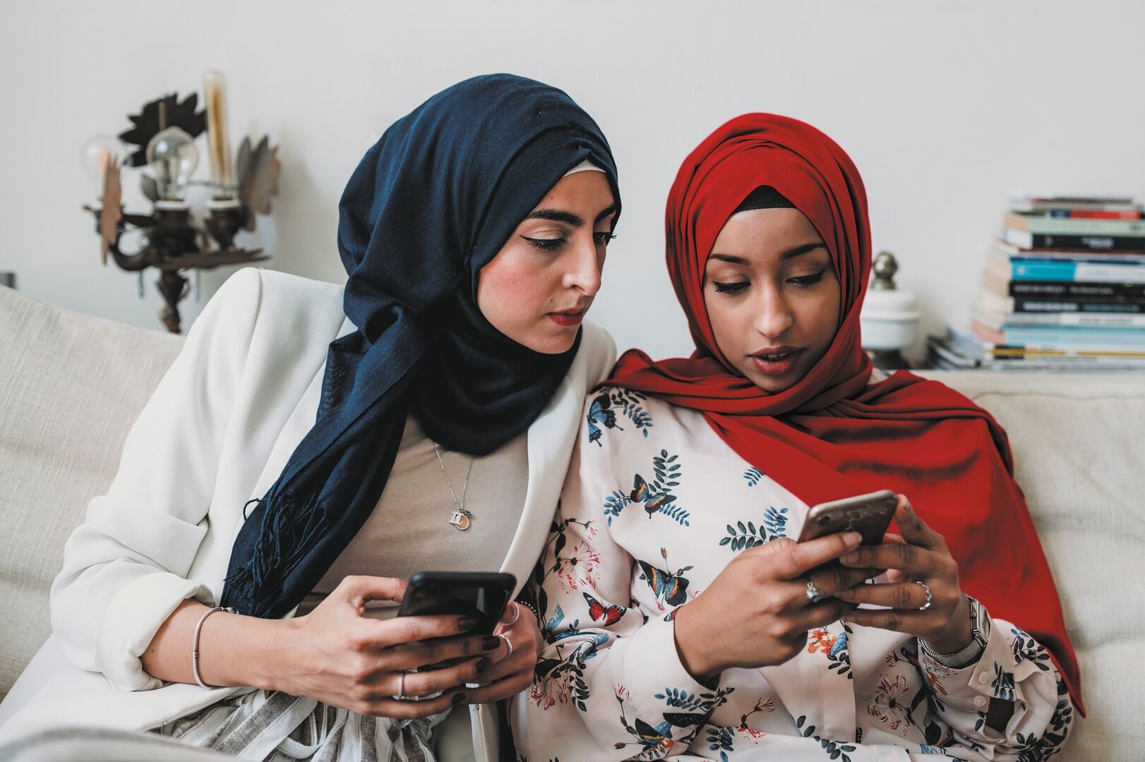 Two Arab Women Wearing Headscarves With Smartphones