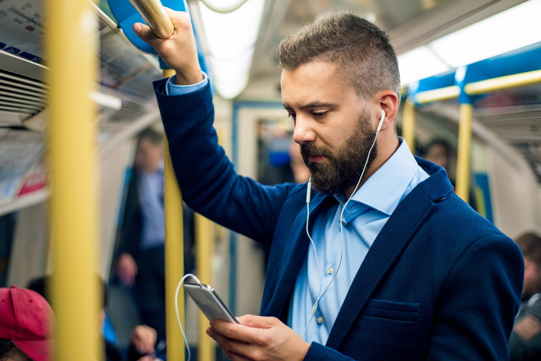 stock photo of a man using a mobile phone while standing in a London Underground train carriage