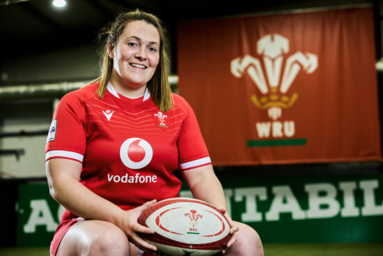 photo of Welsh rugby player Cerys Hale sitting down while holding a rugby ball