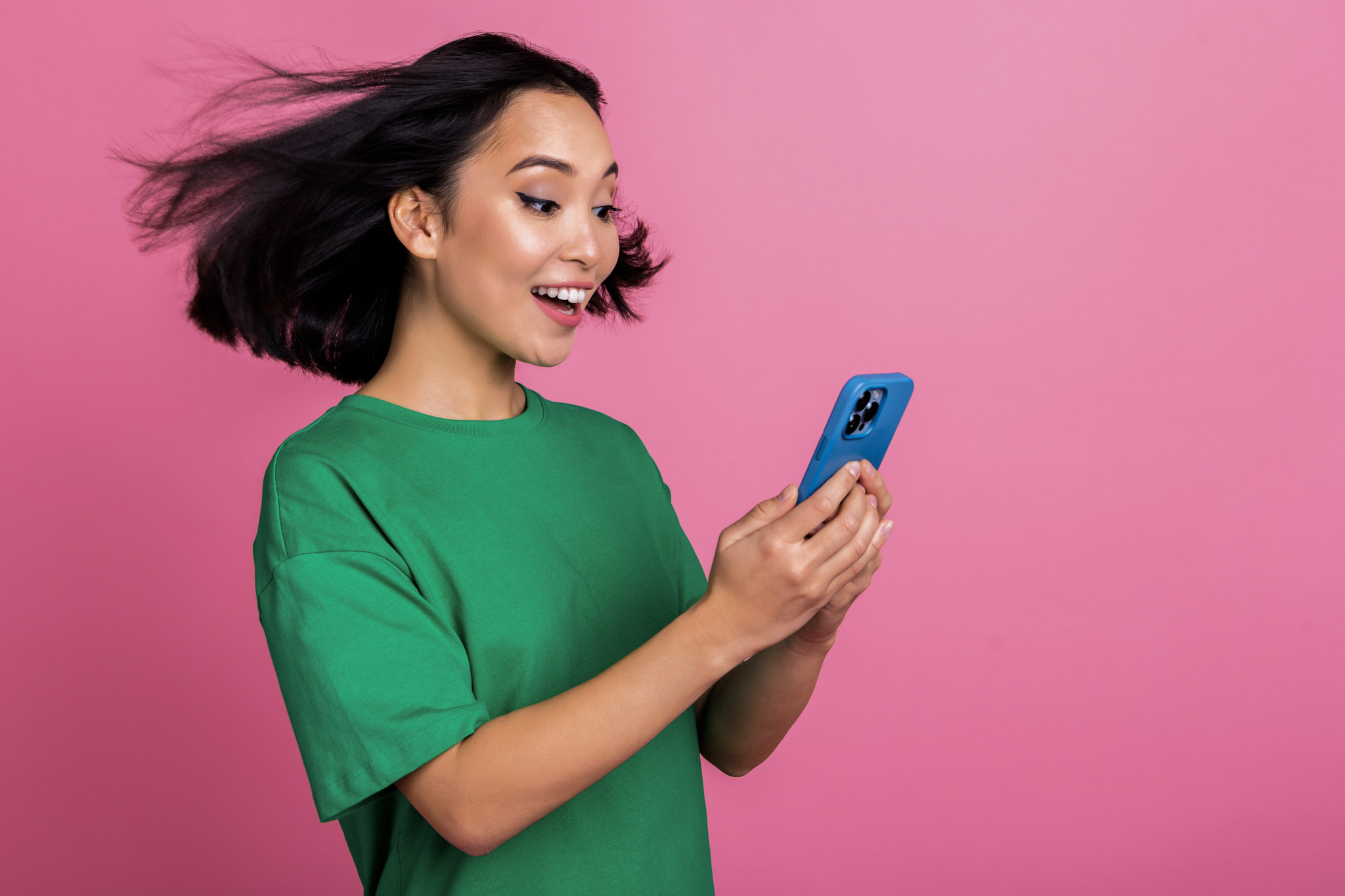 stock photo of an excited/impressed young woman holding a smartphone