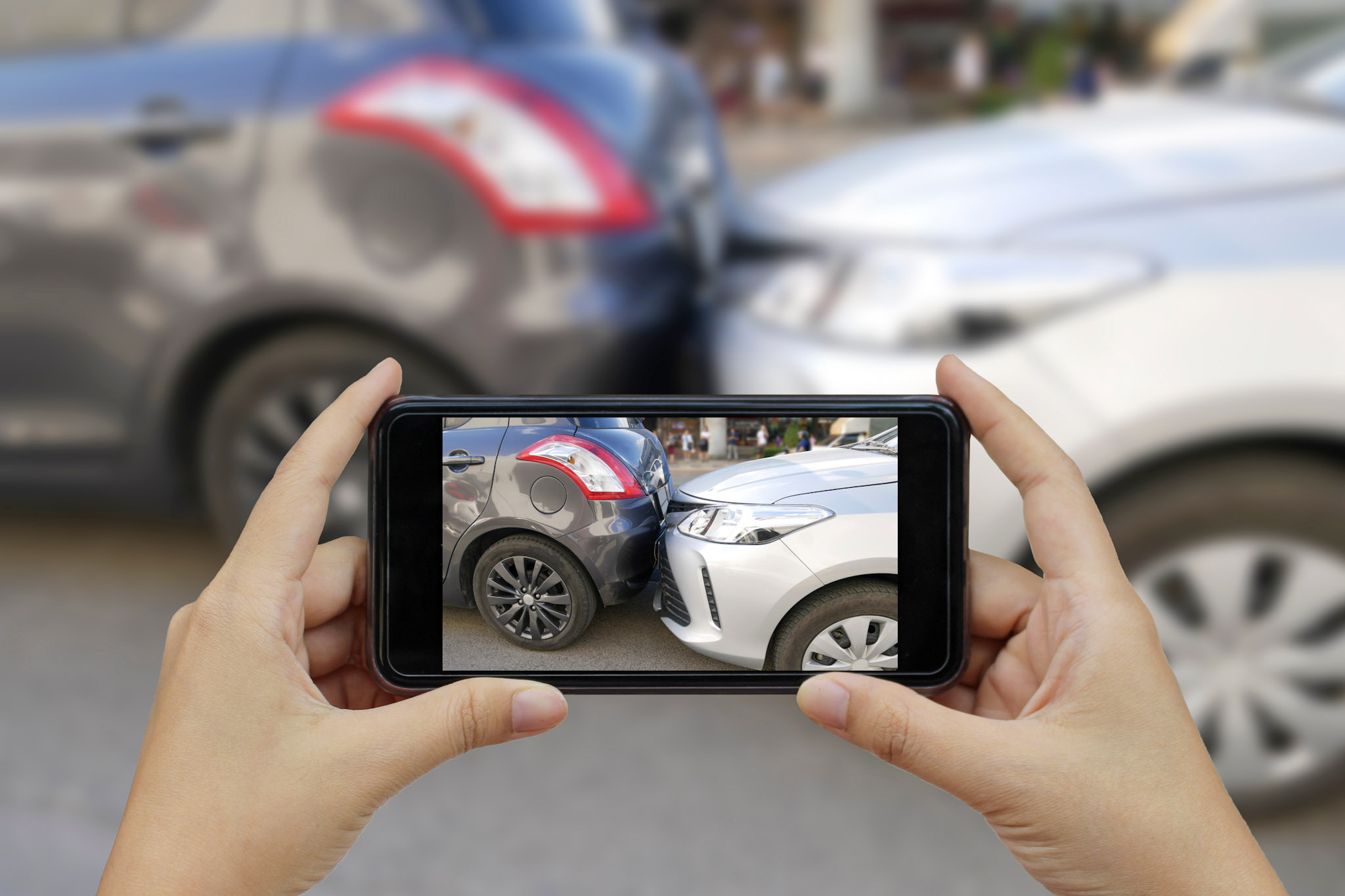 stock photo of a smartphone being used to photograph a minor traffic collision