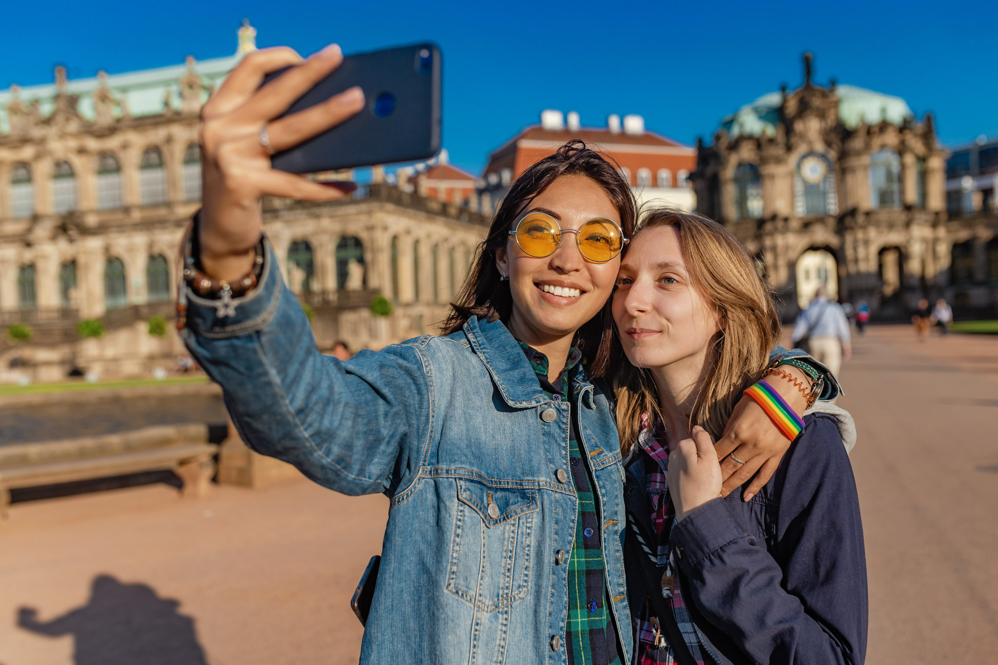 stock photo of a lgbti couple using a smartphone to take a selfie while on holiday