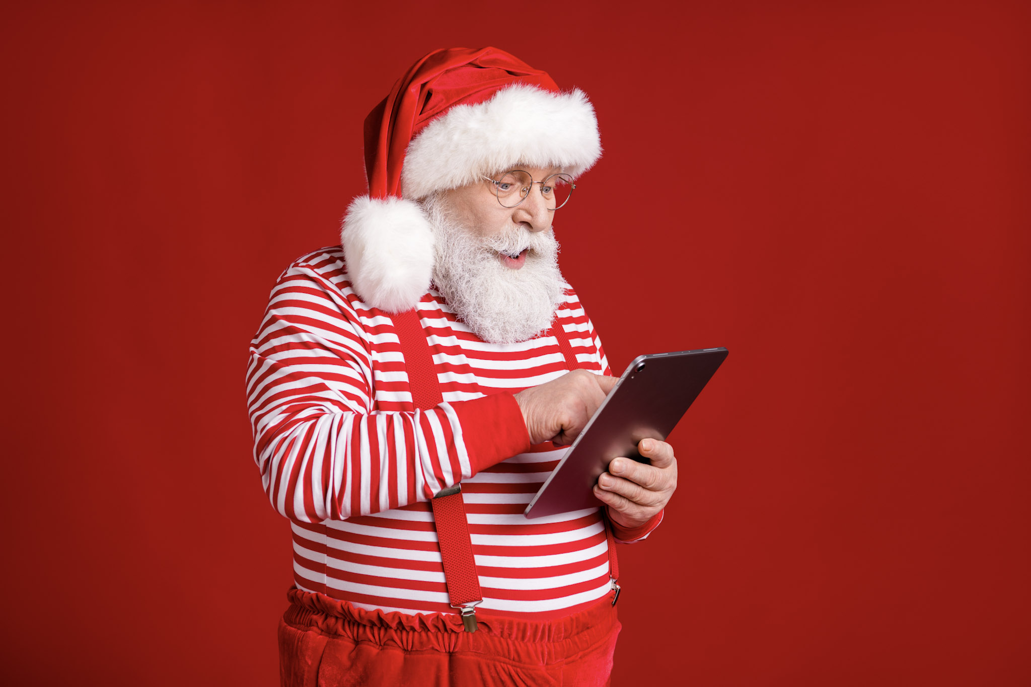 stock image of Father Christmas Santa Claus shopping on a tablet