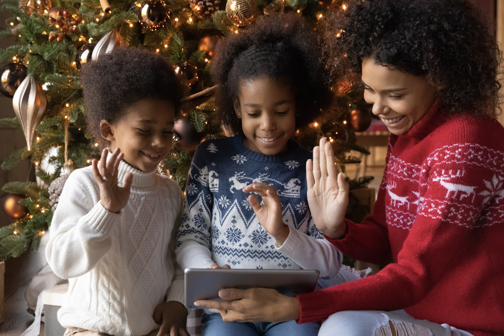 stock photo of a happy family using a tablet to make a video call to relatives on Christmas