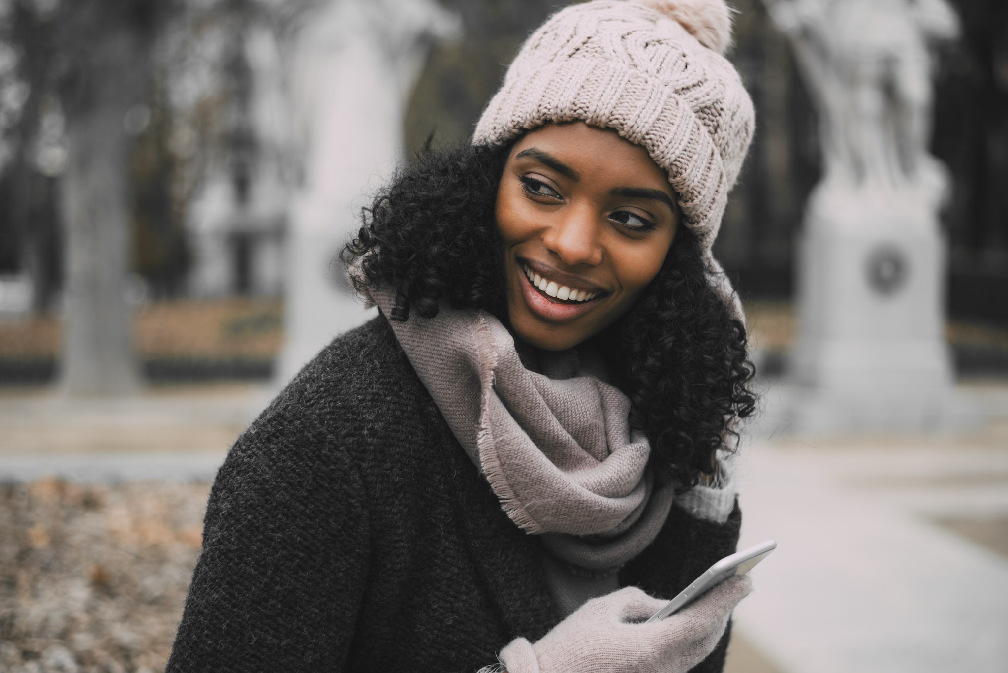stock photo of a young woman in winter clothing using a smartphone