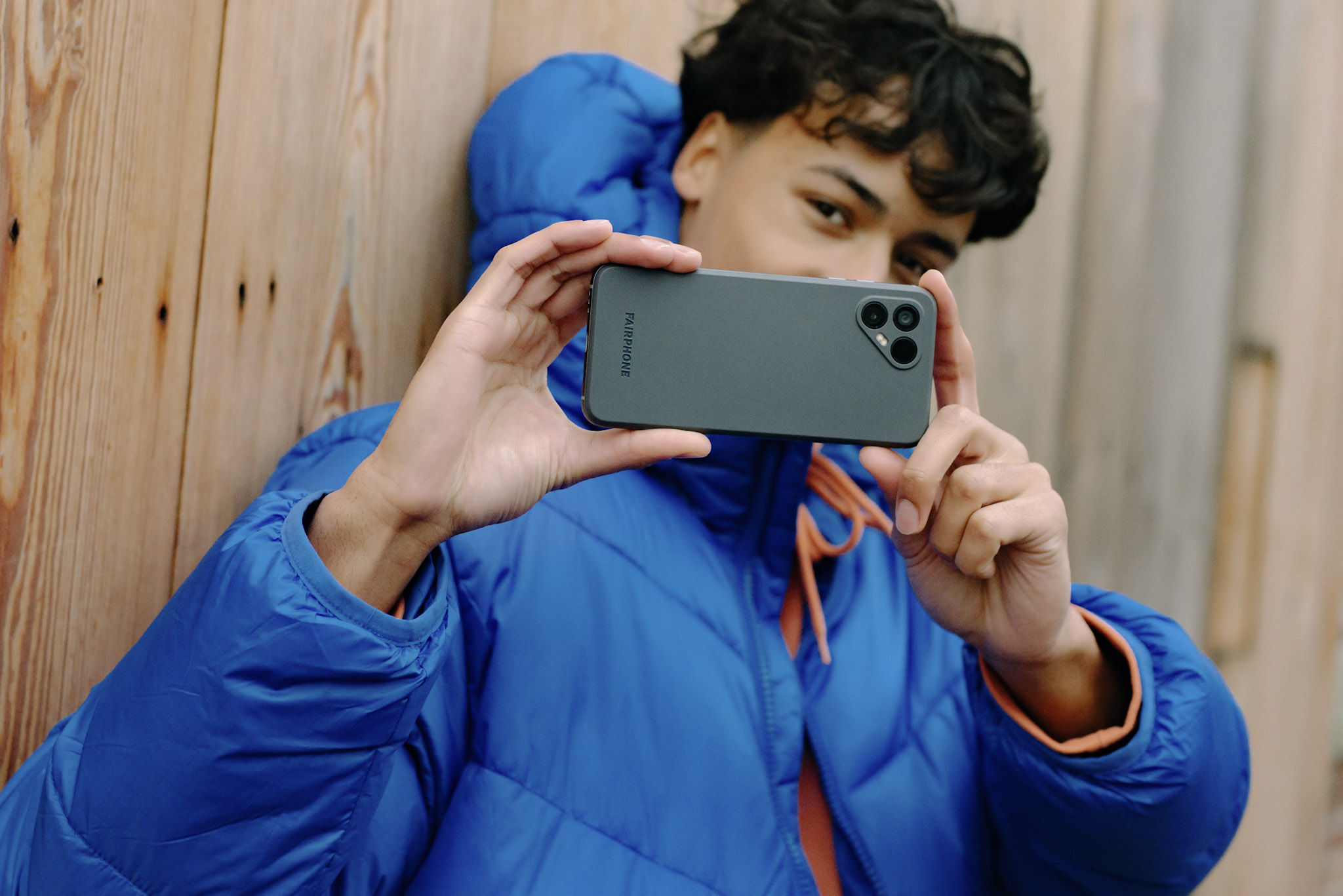 photo of a young man taking a photo using the Fairphone 4 sustainable Android smartphone