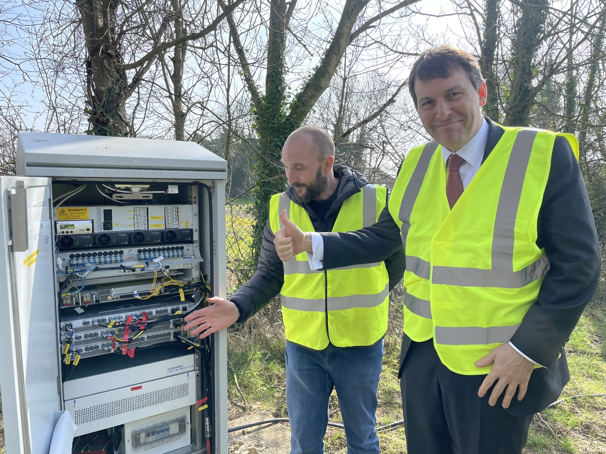 Stuart Fisher (L), a Vodafone UK Network Manager, John Glen MP (R). Fisher shows Glen the computer and equipment cabinet for the Winterslow Vodafone 4G mast.