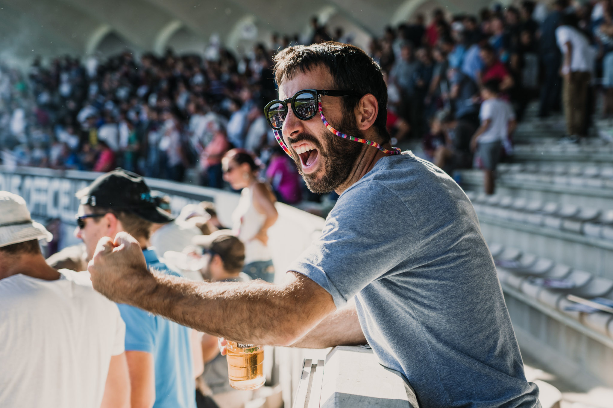 stock image of a happy bearded man in the stands at a stadium enjoying a rugby match