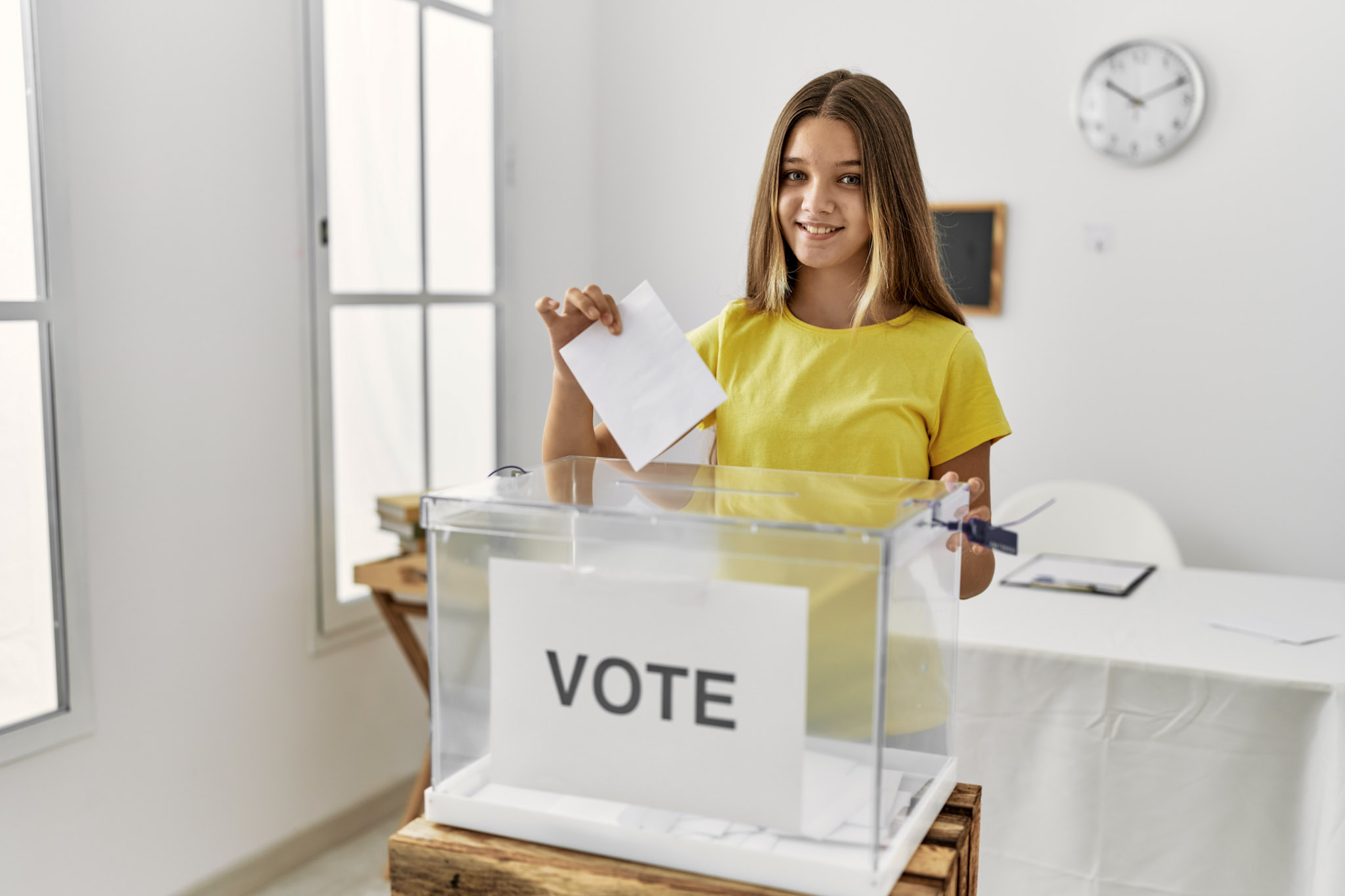 stock photo of a girl smiling while confidently voting at a mock election