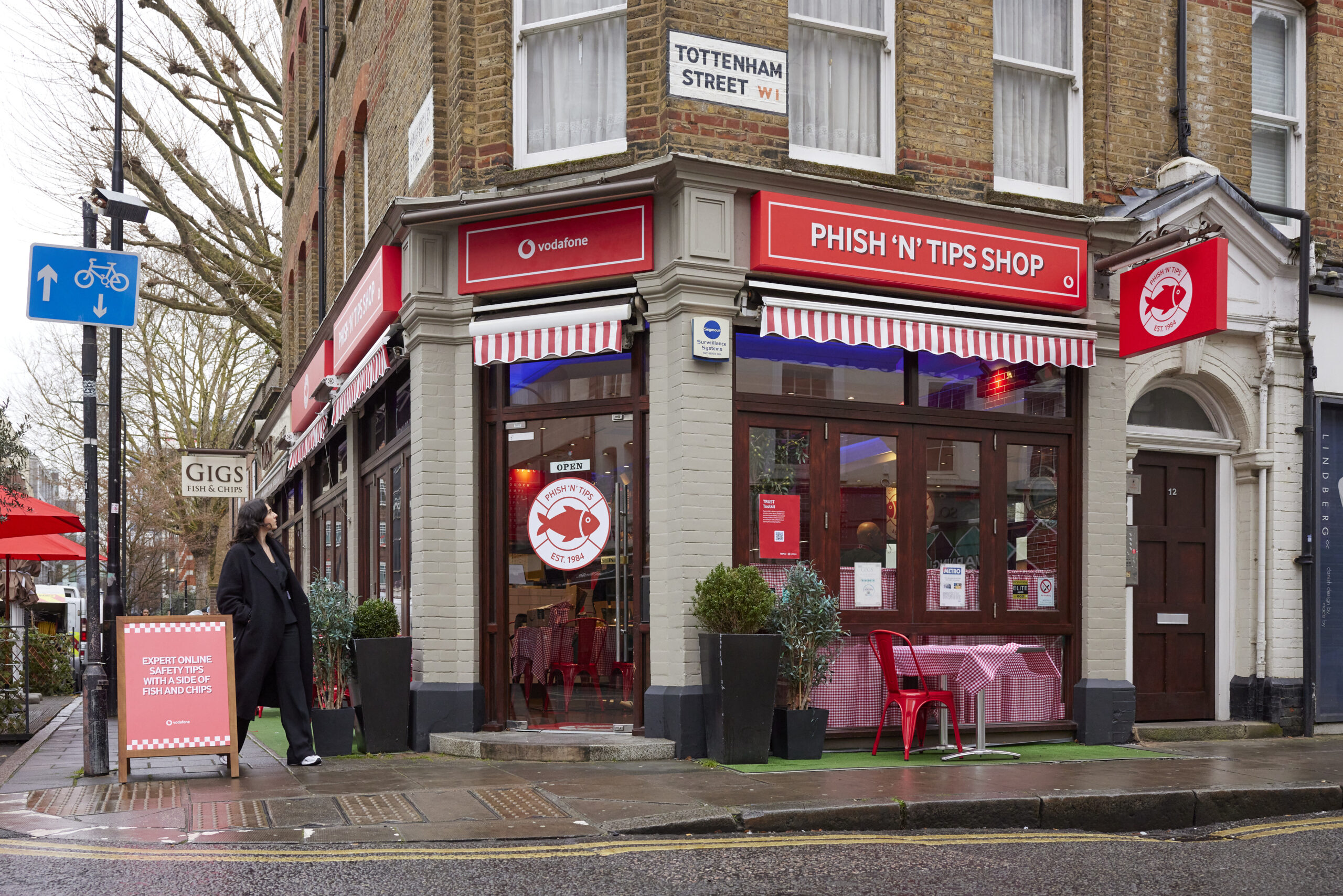 Woman looking up at Vodafone UK's 'Phish 'N' Tips' store on Tottenham Street, London.