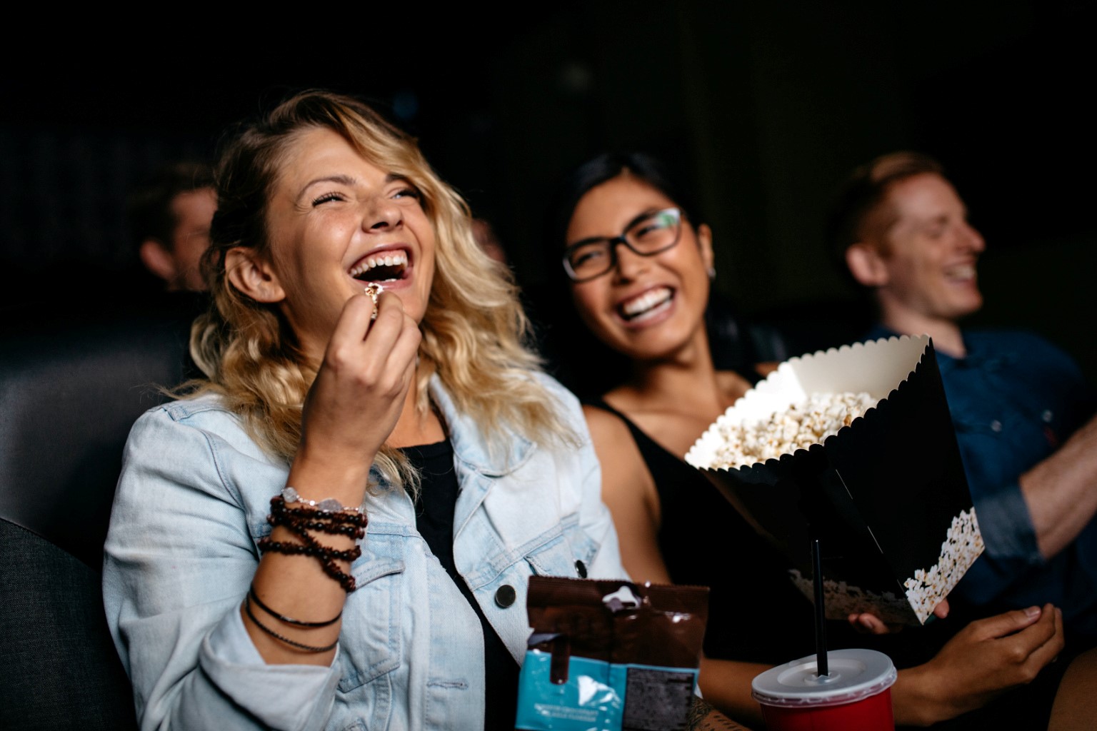 stock photo of two happy women seated in a cinema auditorium