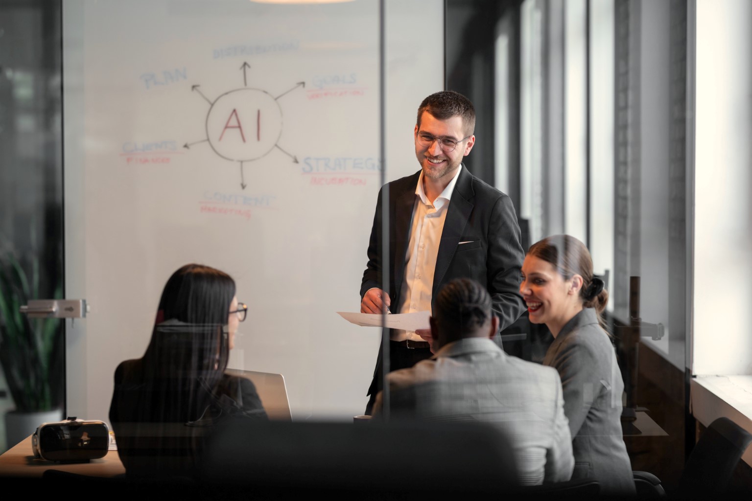 Office workers talking in front of whiteboard featuring AI spider diagram.