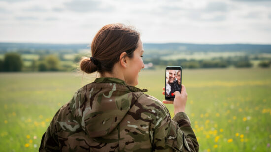 Female armed forces personnel facetiming a loved one.