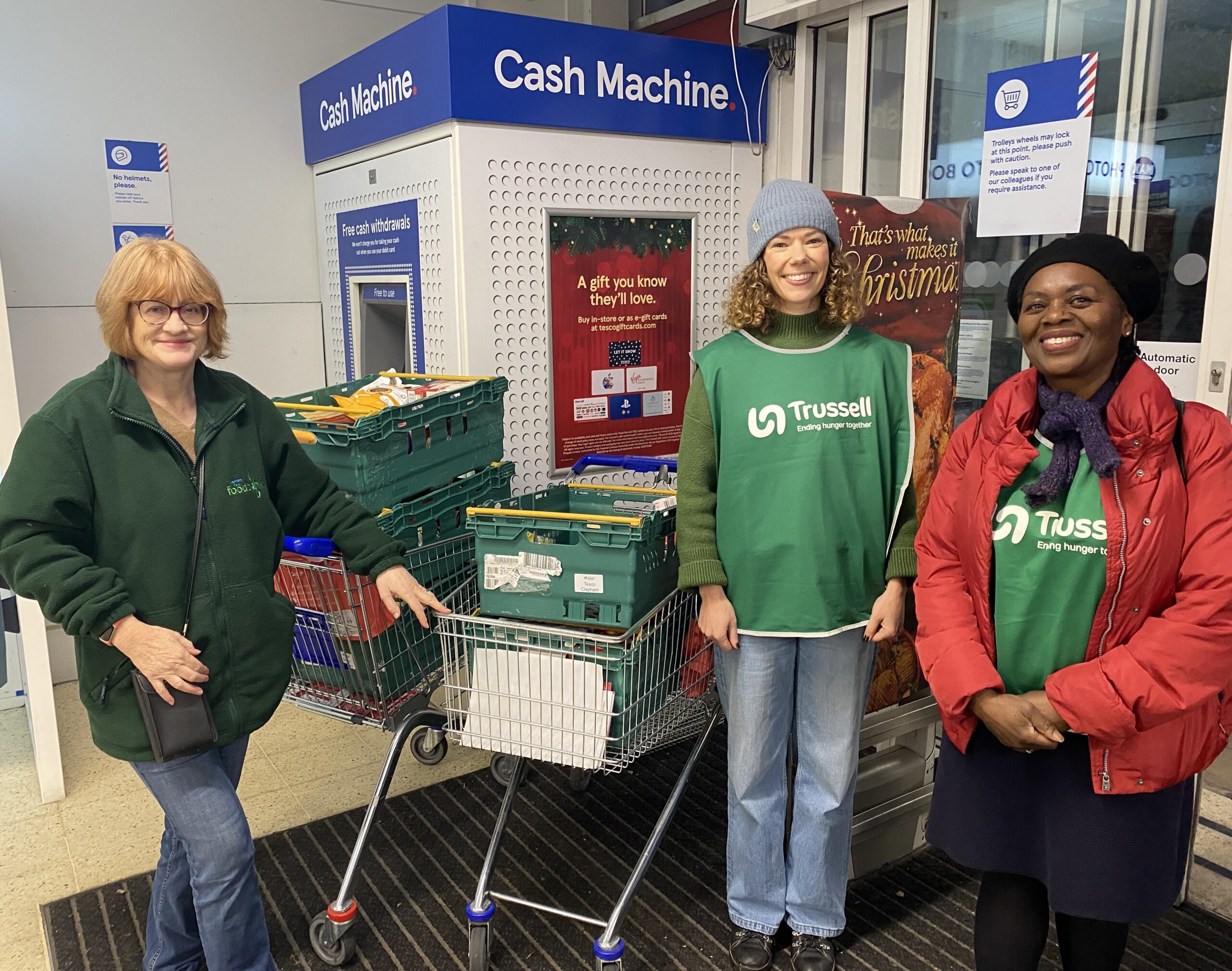 Vodafone and Trussell volunteers standing in a Tesco store during the Tesco Winter Food Collection.