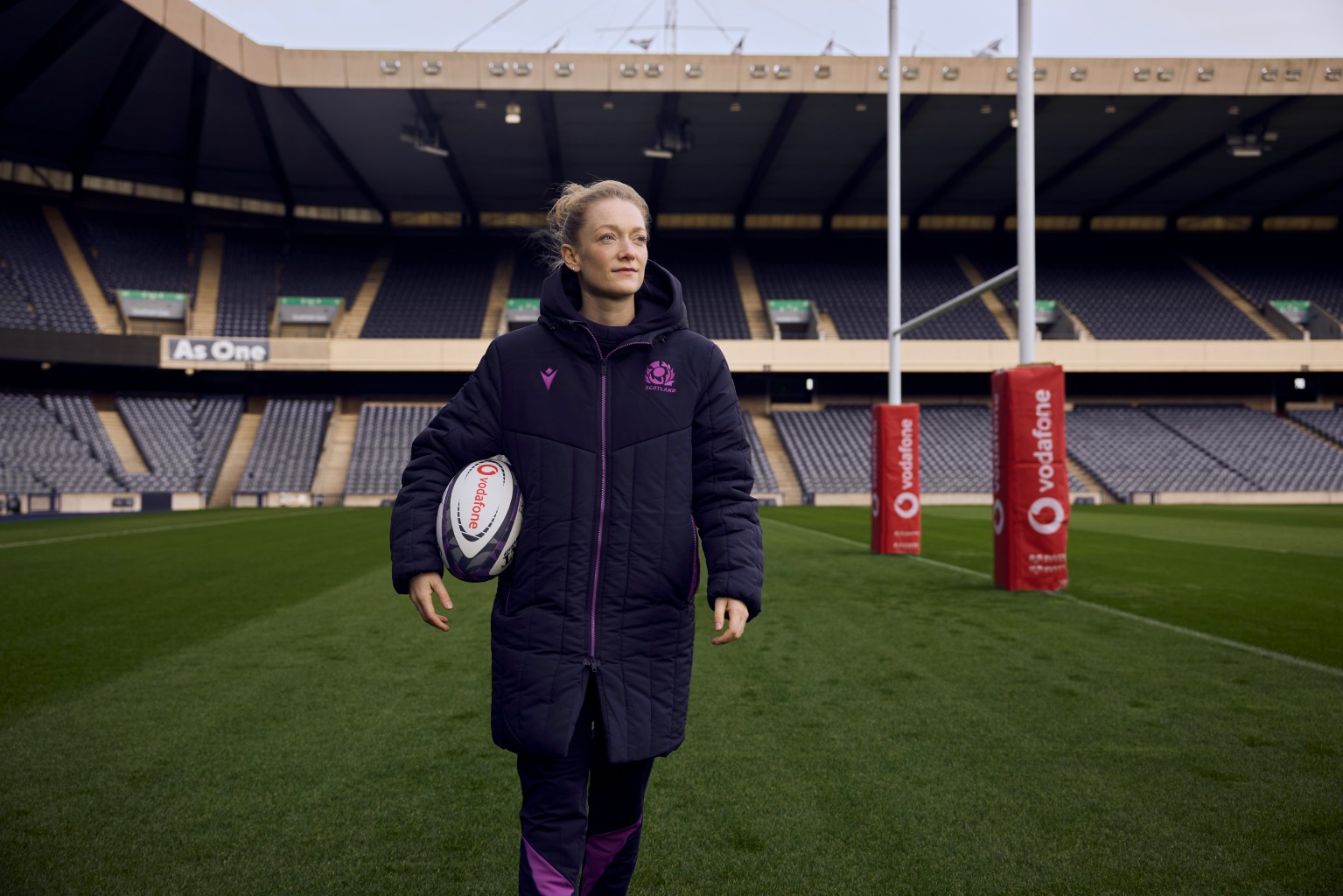 Hollie Davidson holding rugby ball at Murrayfield stadium.