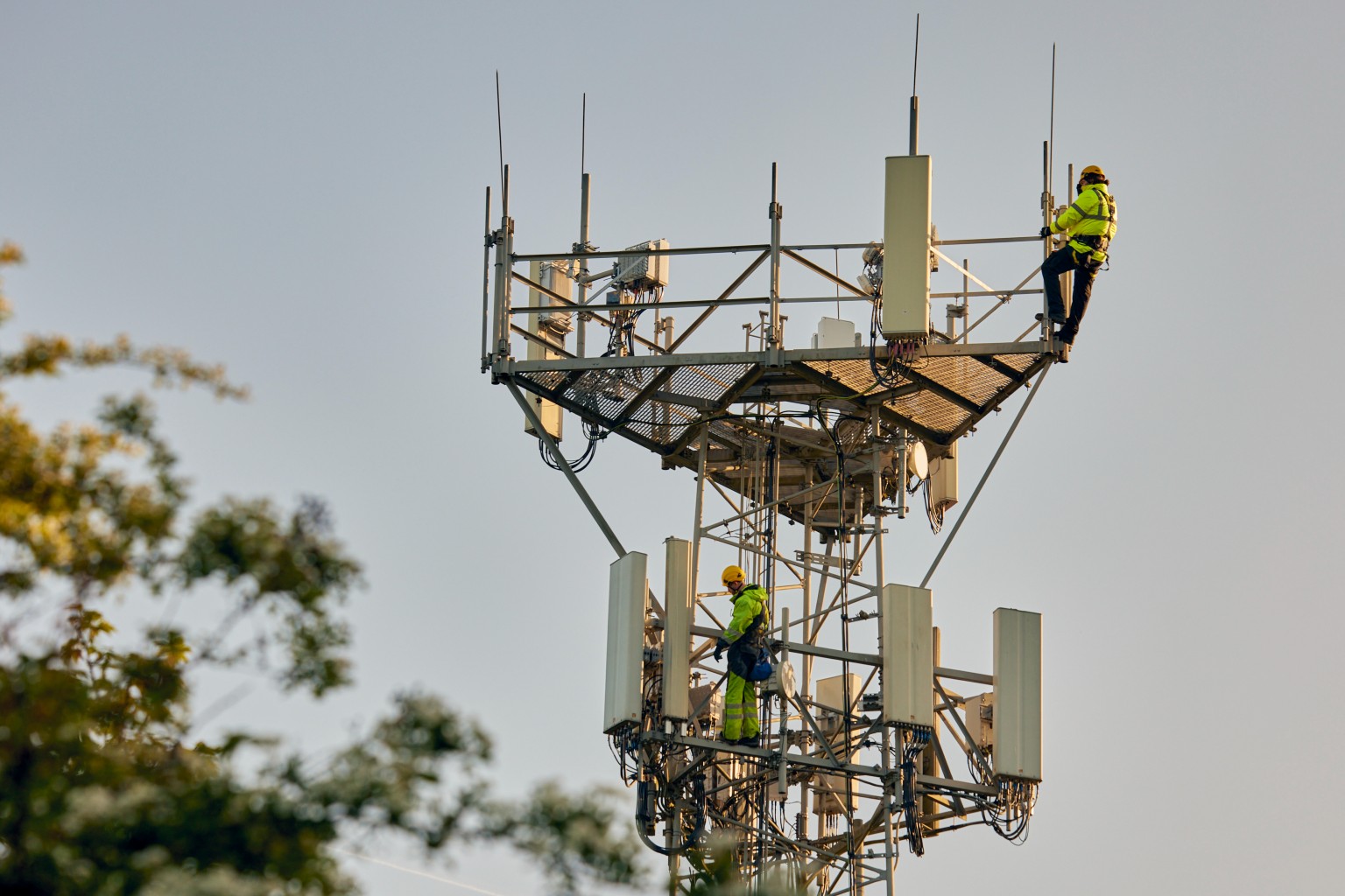 Two engineers climbing telecoms mast.