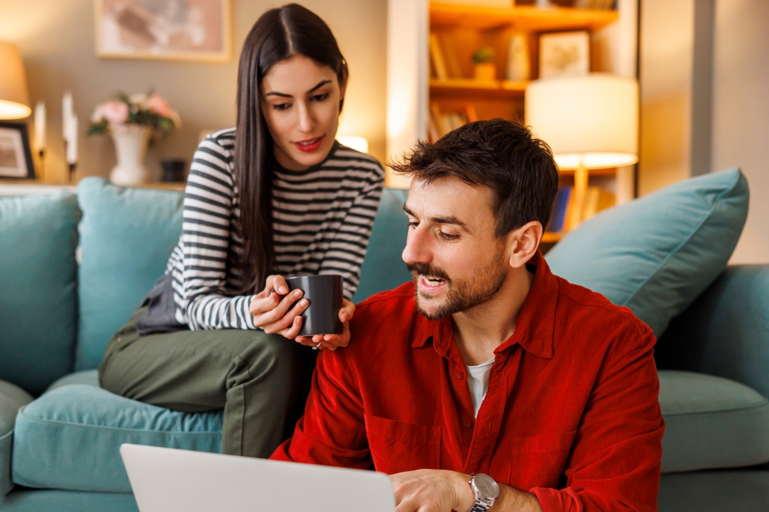 Man and woman talking while using computer.